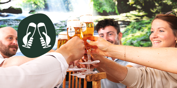 Mehrere Personen sitzen in der Krombacher Braustube und stoßen mit Biergläsern an.