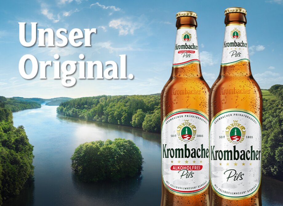 Zwei Flaschen Krombacher Pils stehen vor der Krombacher Insel. Der Text Unser Original. ist sichtbar.