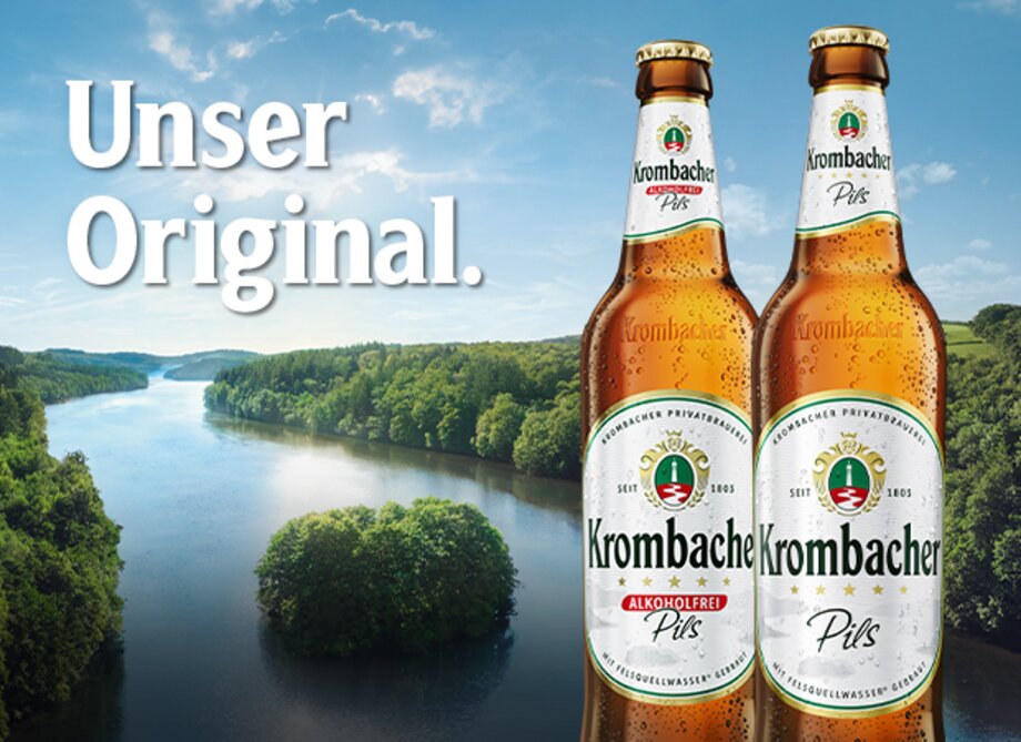 Zwei Flaschen Krombacher Pils stehen vor der Krombacher Insel. Der Text Unser Original ist sichtbar.