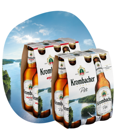 Zwei Sixpacks Krombacher Pils und Pils Alkoholfrei mit Flaschen und Etiketten vor Seemotiv im Hintergrund