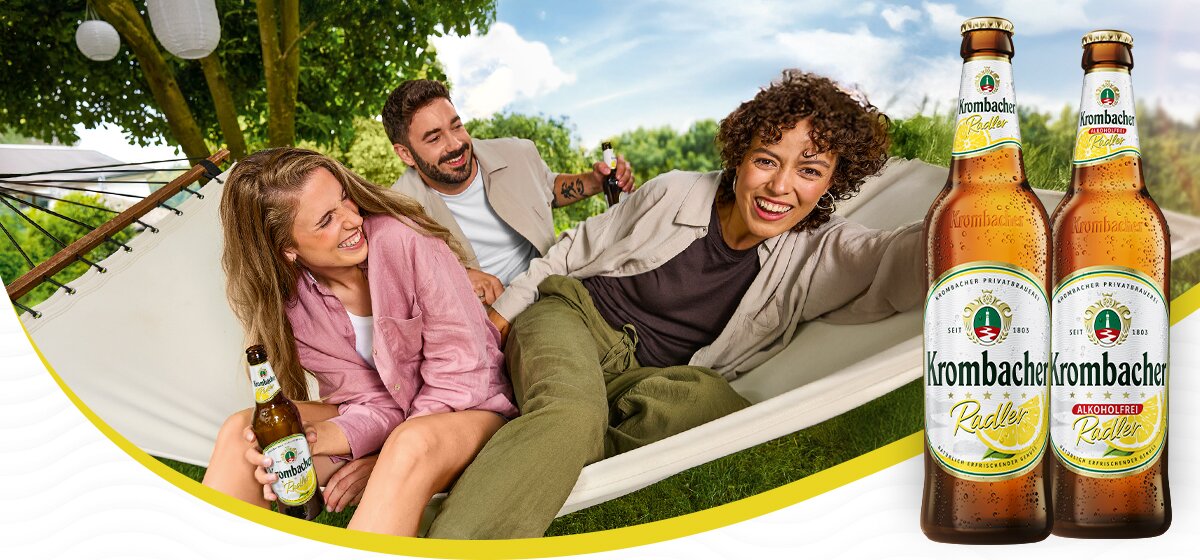 Personen entspannen in einer Hängematte im Grünen neben Krombacher Radler und Krombacher Radler Alkoholfrei.