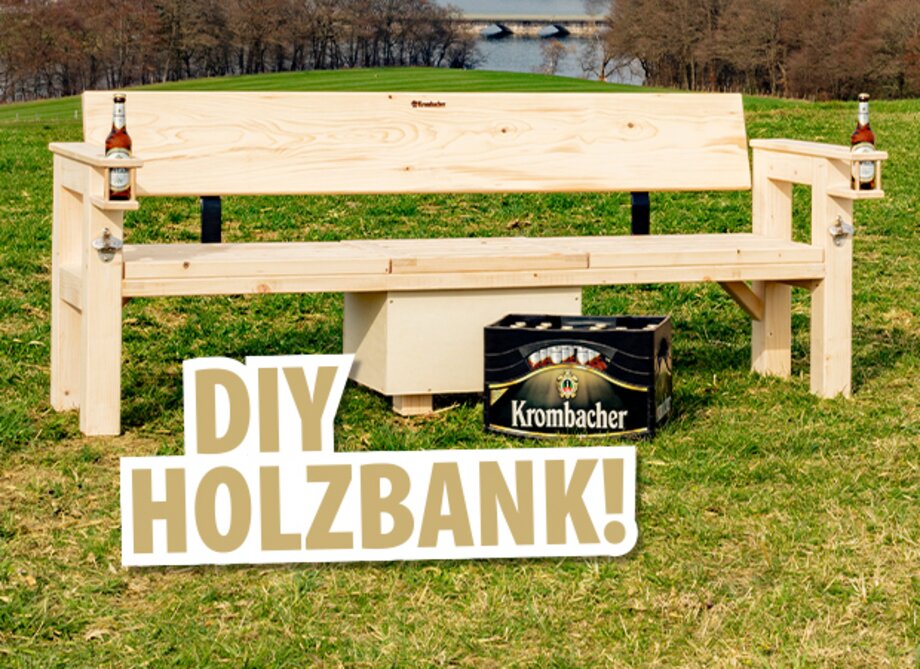 Eine unmontierte Holzbank steht auf einer Wiese, flankiert von zwei Bierflaschen. Der Text 'DIY HOLZBANK!' ist in großen Buchstaben im Vordergrund sichtbar.