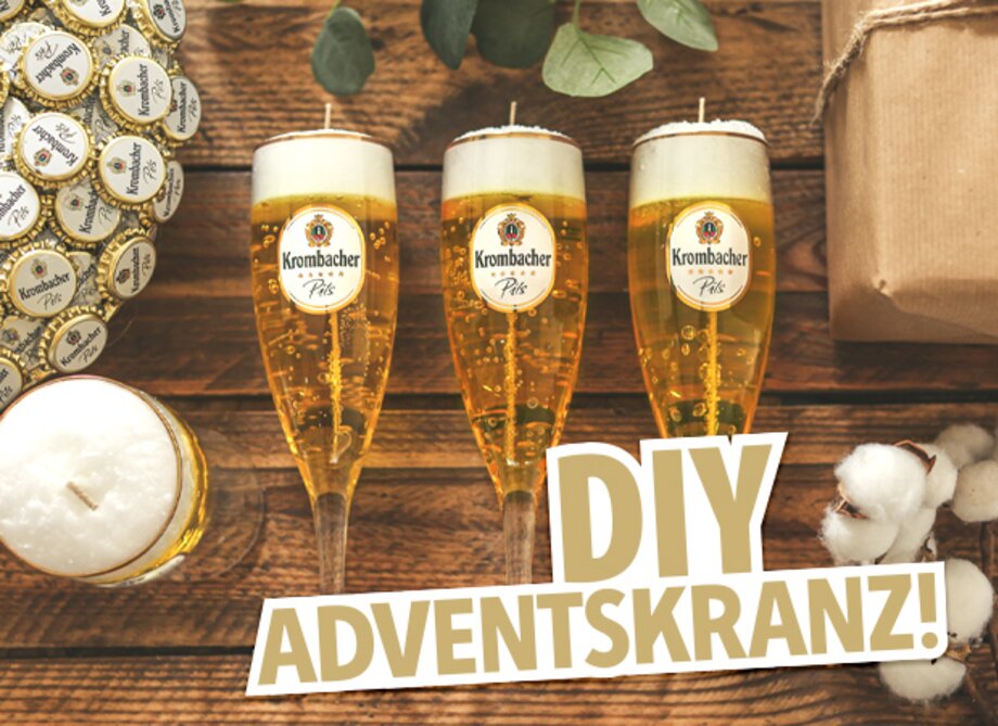 Drei Gläser mit Krombacher Pils, gefüllt mit Bier und einer Kerze oben drauf, stehen auf einem Tisch. Im Hintergrund sind ein Geschenk und eine Kerze sowie der Text 'DIY ADVENTSKRANZ!' zu sehen.