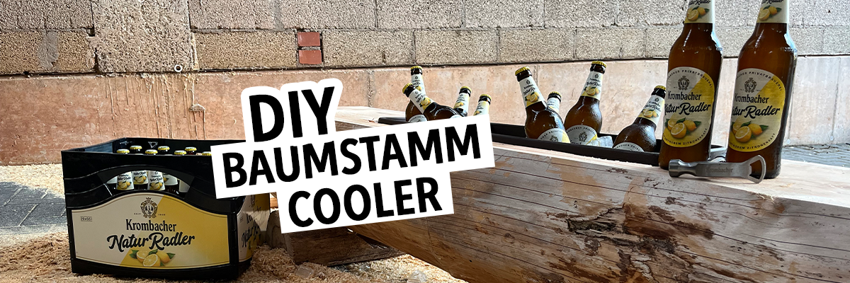 Ein Baumstamm dient als Kühler für Flaschen Bier. Sichtbar sind mehrere Flaschen 'Lindauer Radler' und der Schriftzug 'DIY BAUMSTAMM COOLER'.