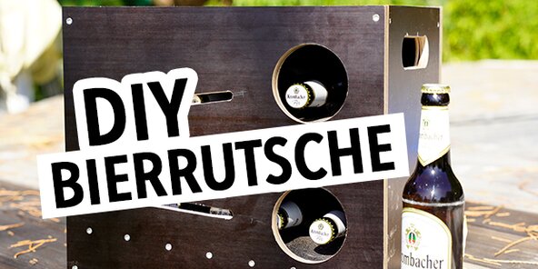 Ein schwarzes Holzgestell mit zwei runden Ausschnitten, in denen Flaschen stehen. Daneben eine Bierflasche von 'Krombacher'. Der Text 'DIY BIERRUTSCHE' ist in großen, weißen Buchstaben auf schwarzem Hintergrund zu sehen.