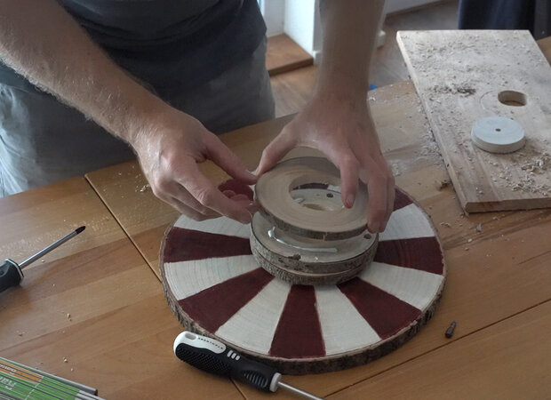 Ausgesägte Drehscheiben werden auf Drehkreisel geklebt.