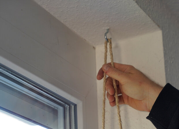 Ein Haken an einer Decke mit einer Kordel.