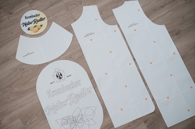 ausgebreitete Schnittmuster des Flaschenkostüms auf einem Boden.