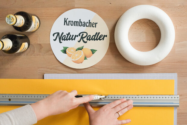 Gelbe Pappe wird für Kronkorken ausgeschnitten.