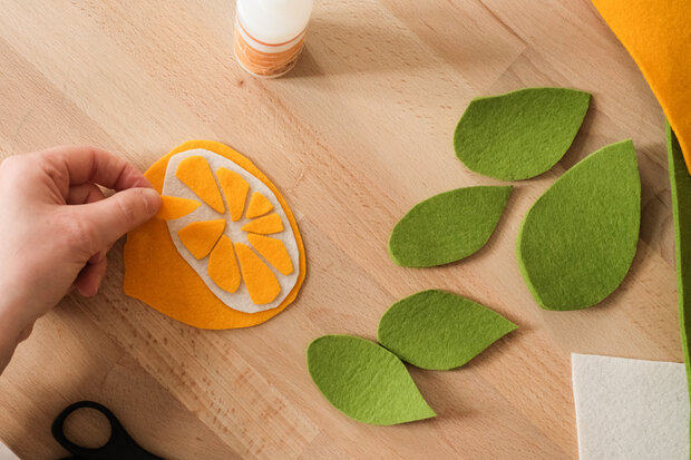 Orangen auf Filz sind ausgeschnitten und zusammegeklebt.
