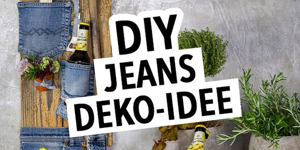 Ein Holzhintergrund zeigt eine kreative DIY-Deko-Idee mit Jeans. Auf der linken Seite hängen Jeans-Taschen mit Werkzeugen. In der Mitte steht der Text 'DIY JEANS DEKO-IDEE'. Unten sind zwei Flaschen mit Etiketten sichtbar.
