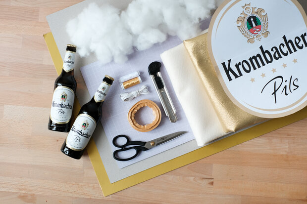 Bastelansammlung in Krombacher Bierfarben und Flaschen, Schere und Draht.