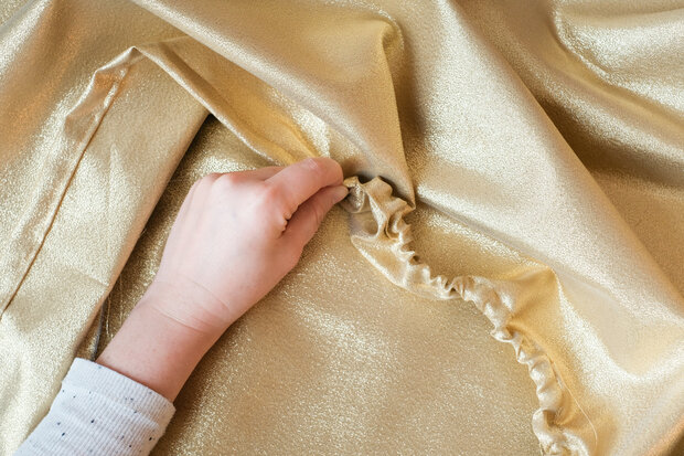 Bei goldenem Stoff wird der Tunnelzug genäht.