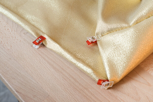 Goldener Stoff mit Klammern befestigt.