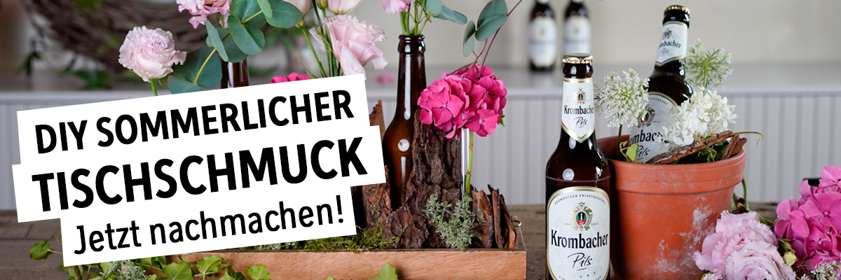 DIY sommerlicher Tischschmuck Jetzt nachmachen. mit Blumen und Krombacher Pilsflasche im Hintergrund.