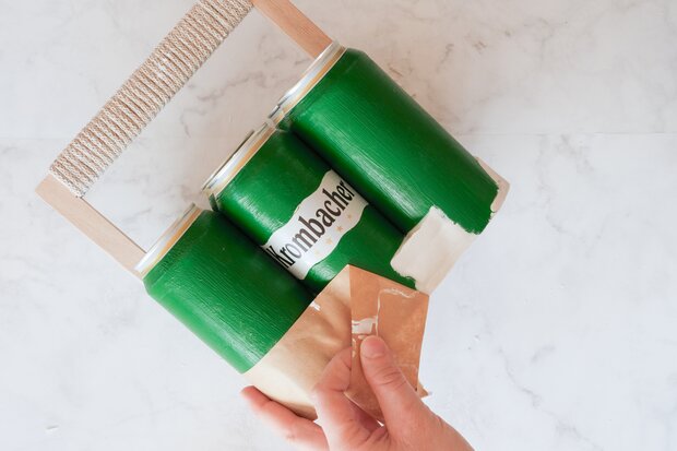 Klebeband wird von grünen Dosen entfernt.