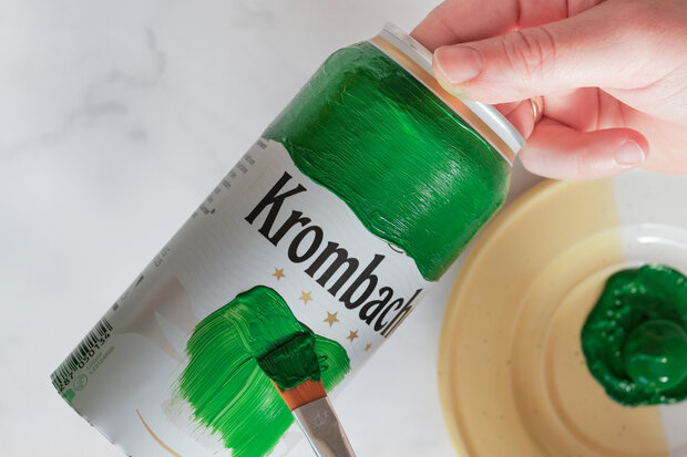 Pilsdosen werden grün angemalt.