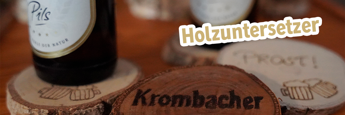 Zwei Krombacher Pils Flaschen auf einem Untersetzer mit Text: Holzuntersetzer.