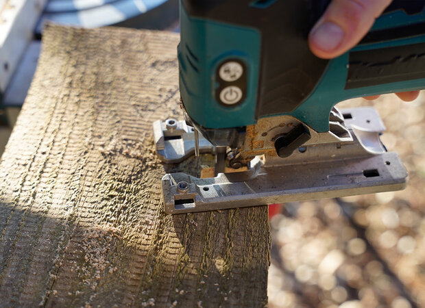 Holzbrett wird mit Stichsäge gesägt.