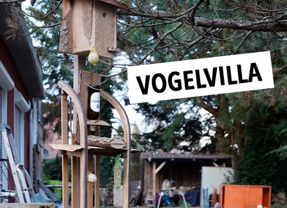 Ein Holzvogelhäuschen mit text: Vogelvilla.
