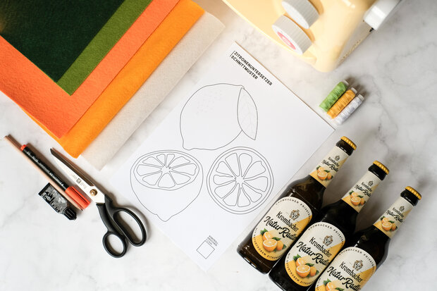 Aufgezeichnete Zitronen mit Krombacher Naturradler Flaschen.