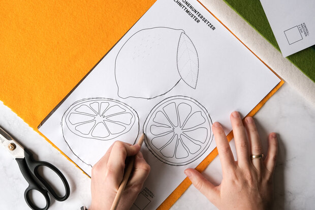 Zitronenformen werden auf gelben Filz übertragen.