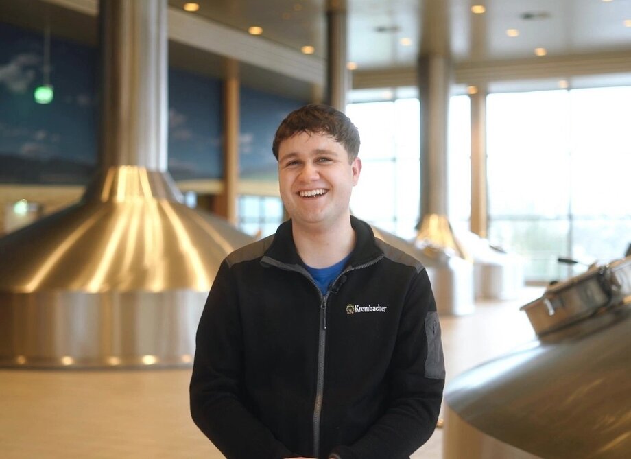 Mann mit kurzen braunen Haaren, trägt einen dunkelgrauen Pullover mit Krombacher Logo Aufdruck.