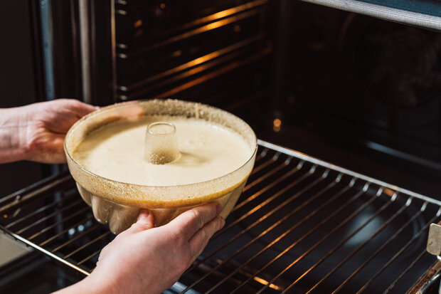 Der Teig wird in einer Kuchenform in der Ofen gelegt.