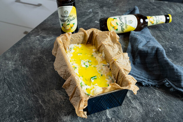 Der Teigmasse in der Brotbackform wird Eigelb hinzugefügt.