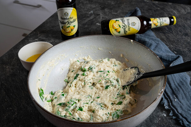Mehl, Rucola und  das Natur Radler werden in einer großen weißen Schüssel umgerührt.