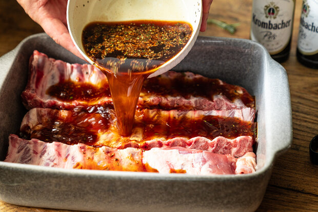 Über die Rippchen wird eine braune Marinade gegossen.