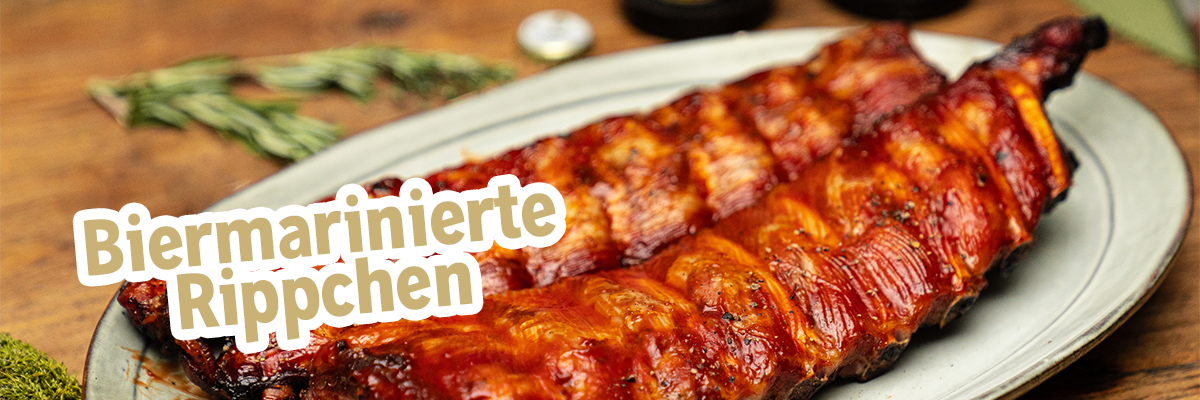 Zwei Biermarinierte Rippchen liegen längs auf einem Teller.