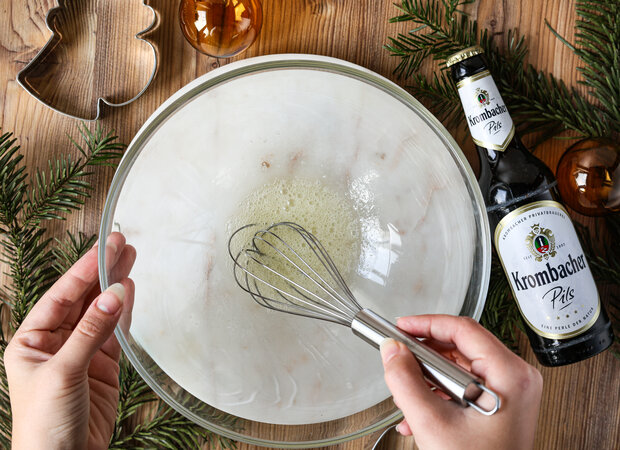 Eiweiß wird mit einem Teelöffel Zitronensaft in einer durchsichtigen Schüssel verrührt.