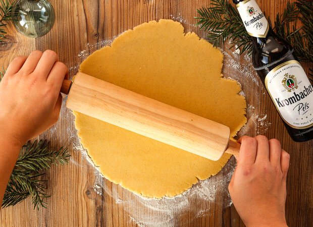 Der Teig wird mit einem Nudelholz ausgerollt.