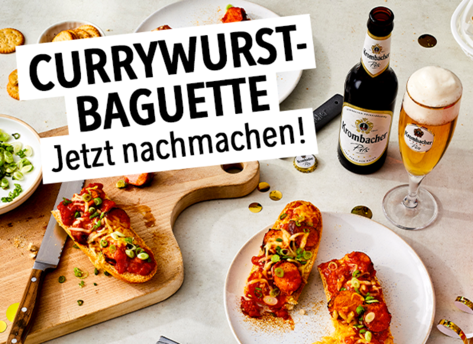 Teile eines selbstgemachten Currywurst - Baguettes auf einer Holzplatte und einem Teller.