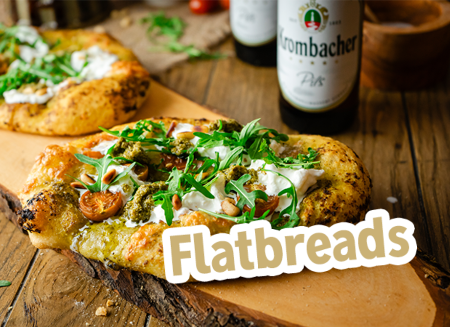 Flatbreads mit Tomaten und Rucola auf einer Hölzernen Platte.