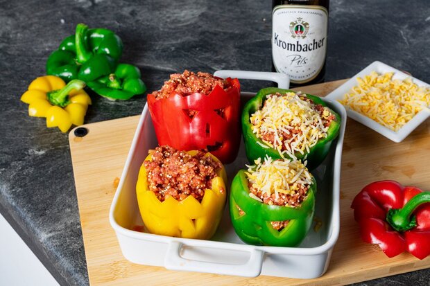 Die Vier gefüllten Paprikas liegen in einer Auflaufform.