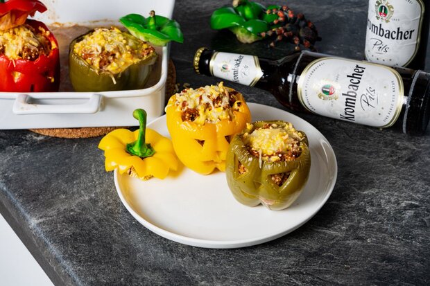 Zwei fertige gefüllte Paprikas liegen auf einem Teller.