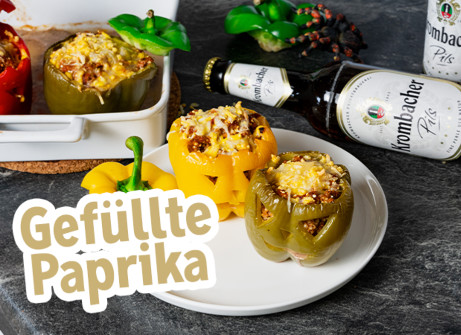 Zwei fertige gefüllte Paprikas liegen auf einem Teller.