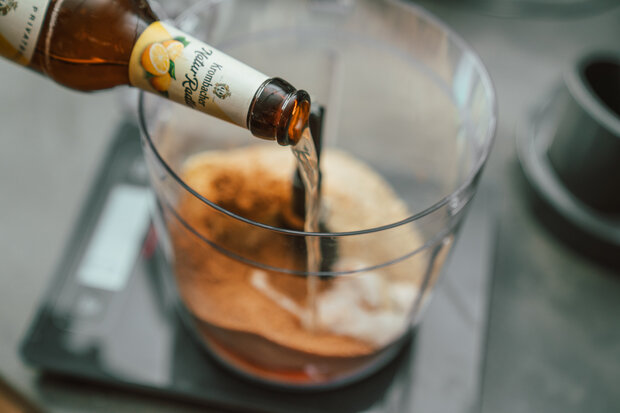 Krombacher Natur Radler wird in eine durchsichtige Rührschüssel gegossen.