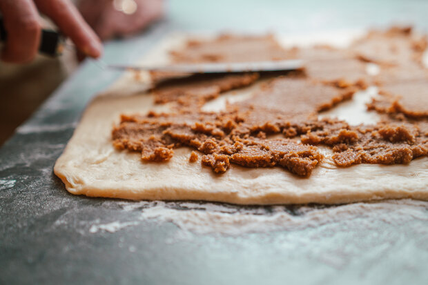Der Teig wird mit einer braunen Masse bestrichen.