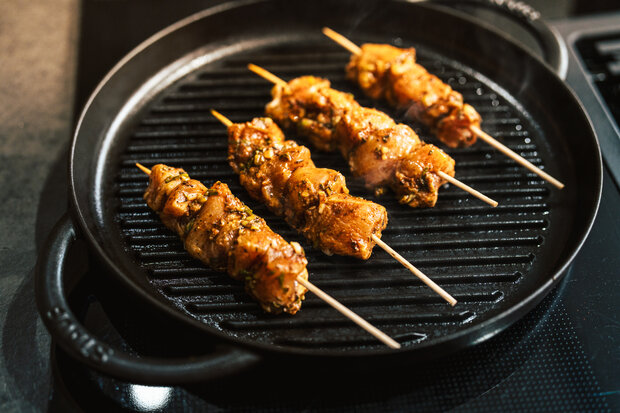 Die Hähnchenspieße liegen auf dem Grill.