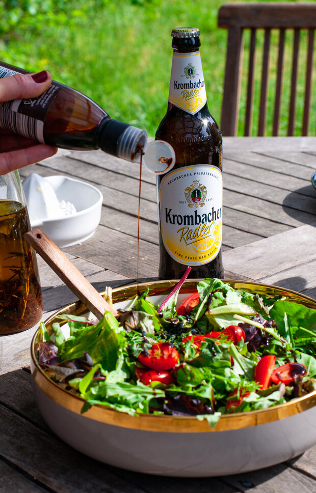 Der Salat wird mit Balsamico-Essig abgeschmeckt