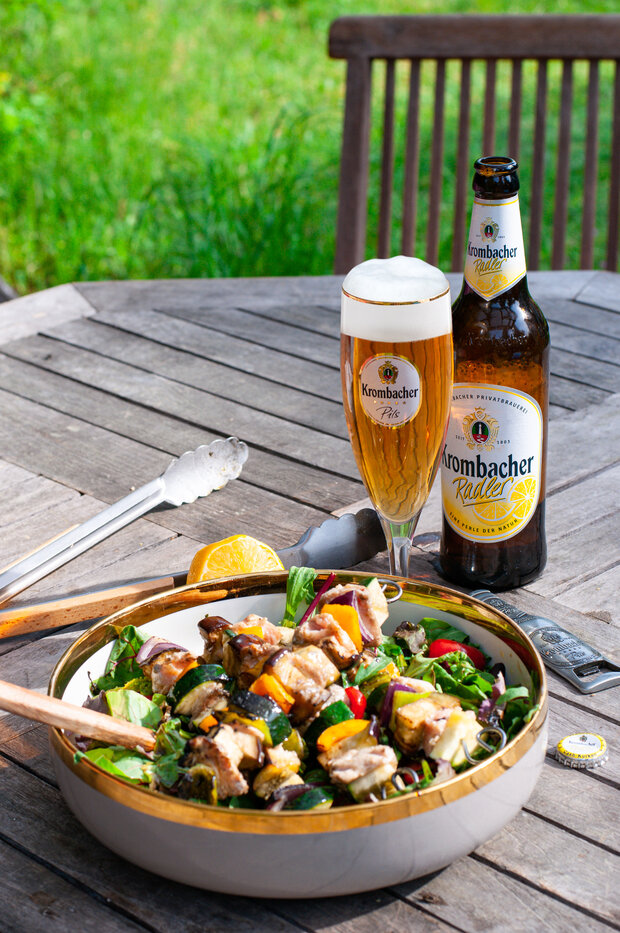 Die Lachsspieße werden zusammen mit dem Salat in einer kleinen Schüssel angerichtet.