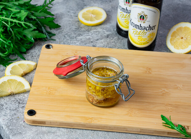 Ein geöffnetes Einmachglas steht auf einem Holzbrett.