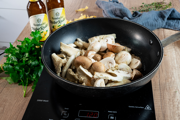 Pilze liegen in einer Pfanne.