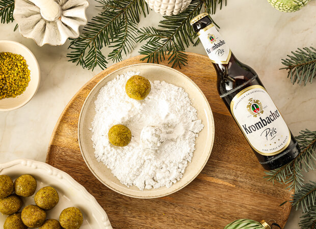 Die Kugeln liegen auf einem Teller voll mit Puderzucker.