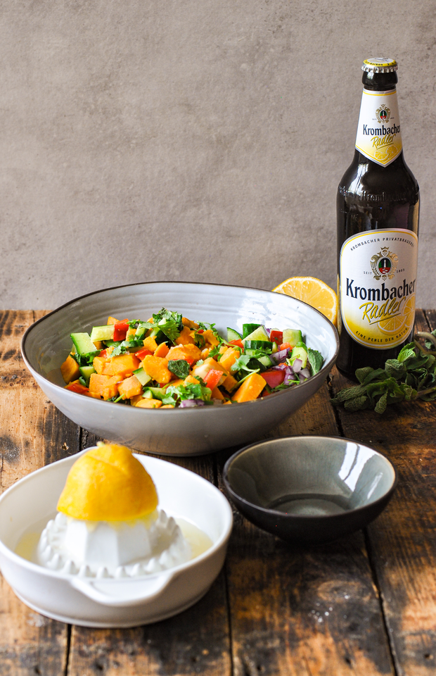 Zum Süßkartoffelsalats wird eine Zitrone gepresst.