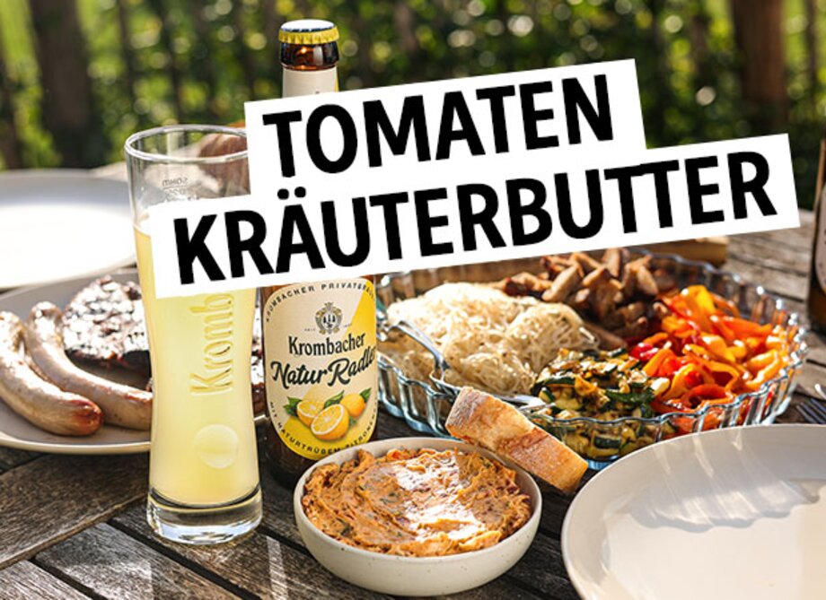 Selbstgemachte Tomatenkräuterbutter auf einem Holztisch mit Grillgut.