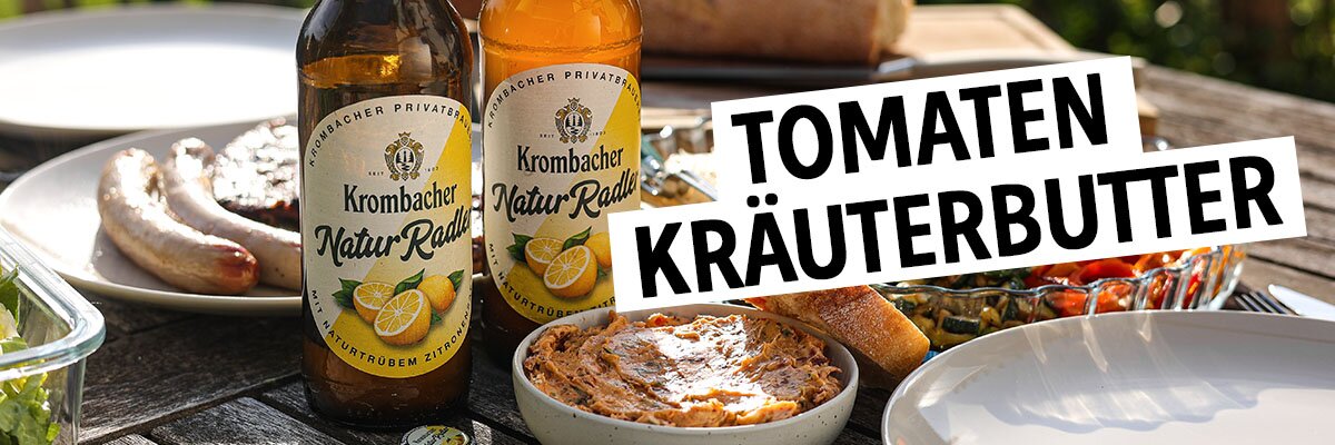 Selbstgemachte Tomatenkräuterbutter auf einem Holztisch mit Grillgut.